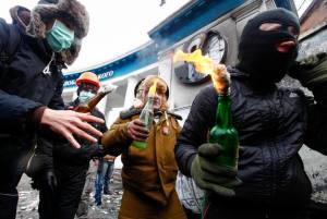 Pro-European integration protesters carry Molotov cocktails during clashes with police in Kiev